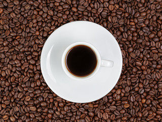 cup of coffee in coffee beans