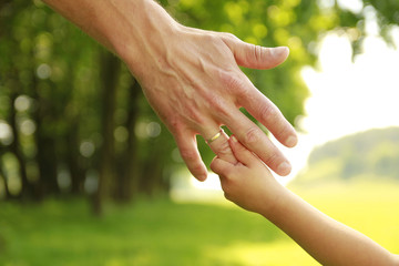hand of parent and child in nature