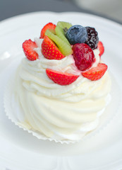 White creamy cake with strawberries on a plate