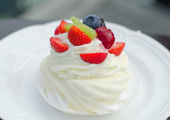 White creamy cake with strawberries on a plate
