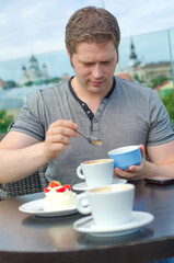 Young man have a rest with cup of coffee in outdoor cafe