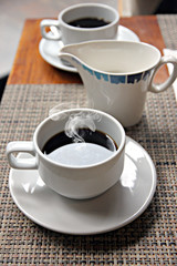 Hot Black coffee in a white cup.