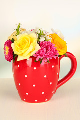 Beautiful bouquet of bright flowers in color mug,