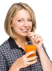 Young woman is drinking carrot juice