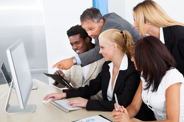 Group Of Businesspeople Looking At Computer