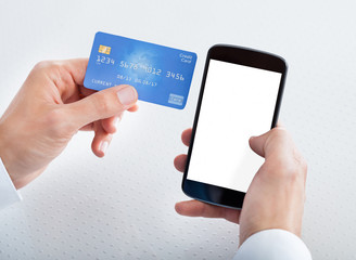 Man Holding Credit Card And Cell Phone