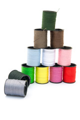 colorful bobbins stack up on white background