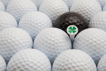 White and black golf balls and wooden tee