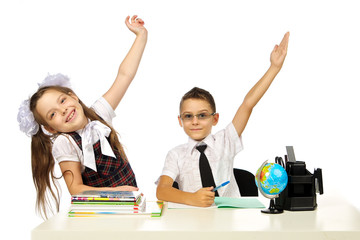 a boy and a girl at the desk raised their hands