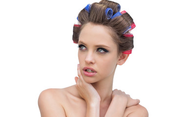 Naklejka premium Seductive lady in hair rollers posing and looking away