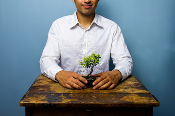 Happy man with his growing bonsai tree