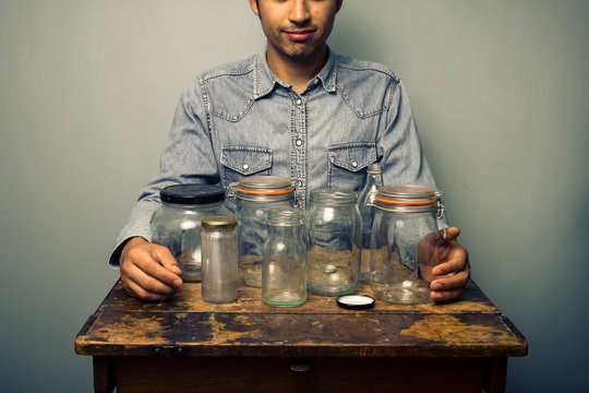Man with empty jars at old desk