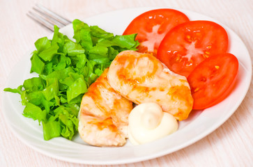chicken breasts on a plate with fresh vegetables