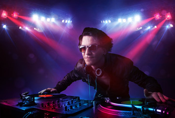 Teenager dj mixing records in front of a crowd on stage
