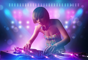 Fototapeta na wymiar Disc jockey mixing music on turntables on stage with lights and