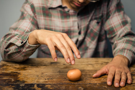 Man spinning an egg on the table