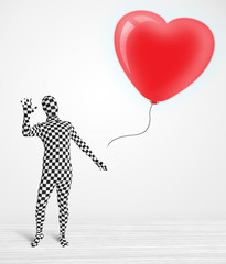 Cute guy in morpsuit body suit looking at a balloon shaped heart