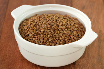 buckwheat in white bowl in dark background