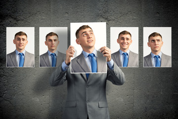 young man holds up a photograph