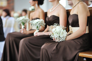 Row of bridesmaids with bouquets at wedding ceremony