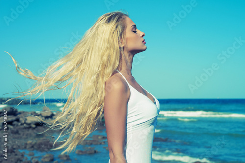 Девушка на пляже в развивающимся на ветру плье скачать