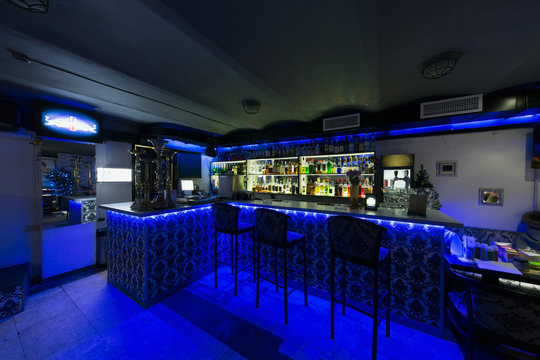 bar counter with chairs illuminated with blue light