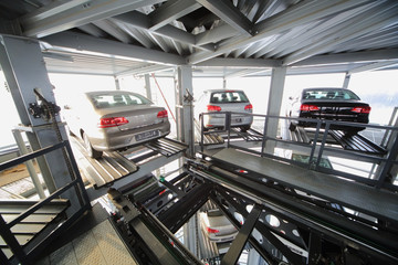 Three vehicles on the top floor of a transparent construction