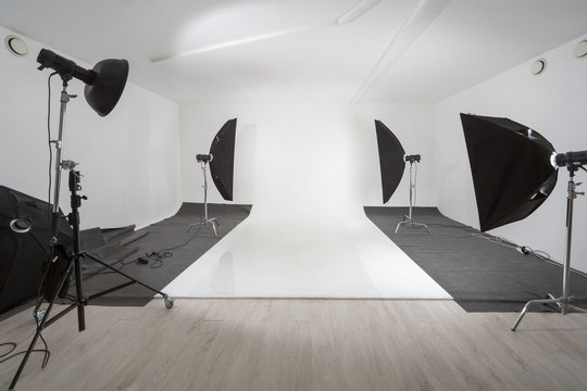 Studio with photographic equipment and white backdrop