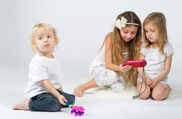 girls playing on gaming device and boy playing with toy