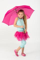 A little girl in a pink skirt is chilly with a pink umbrella