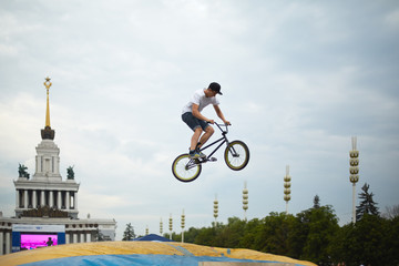 Young man jumps on bike