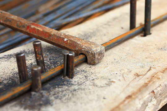 worker bending steel for construction job