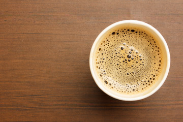 Top view of a cup of black coffee on wooden table