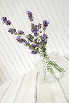 Glass vase with lavender on a white table