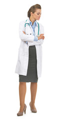 Full length portrait of doctor woman looking down on copy space