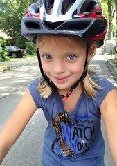 young girl with bicycle and helmet