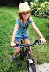 young girl with bicycle in garden