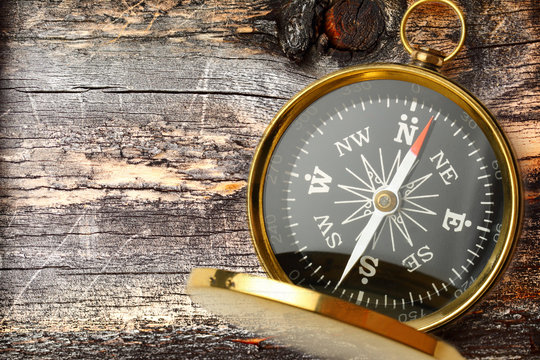 Compass on cracked wooden background