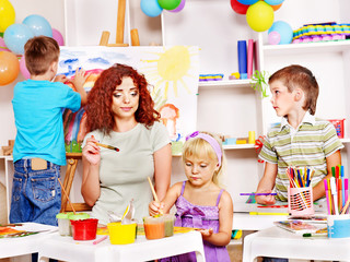 Fototapeta premium Child painting at easel.