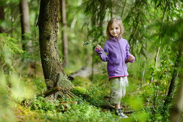 Adorable little girl hiking in the forest