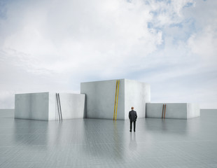 Obraz premium man in front of cubes of different height with ladders