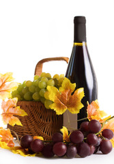 Bottle of wine with grapes in basket