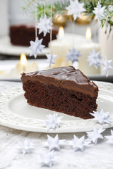 Piece of chocolate cake in white christmas table setting