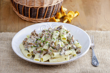Macaroni with mushrooms on wooden rustic table. Autumn setting