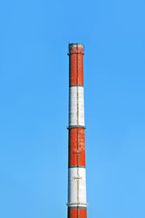 Chimney of industrial plant against blue sky background
