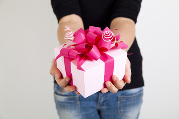 pink gift box with ribbon in woman hands