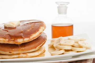 Stack of pancakes with honey and banana.