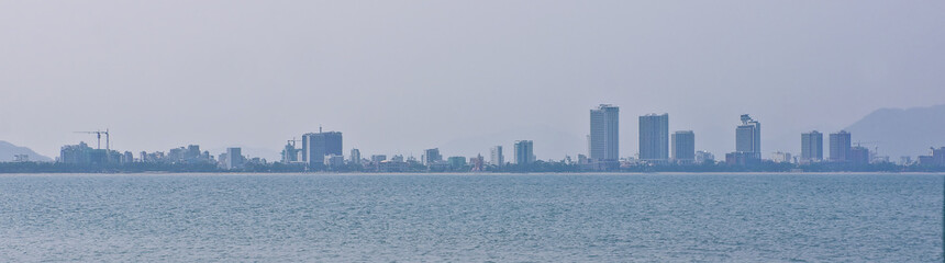 Fototapeta na wymiar Panorama of the big city. The review from the sea on beaches and