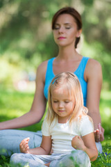 Mother and daughter doing exercise outdoors