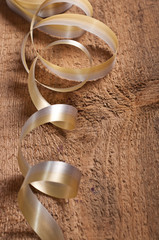 Gold ribbons on wooden background
